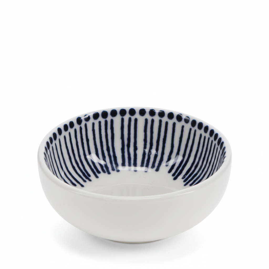 A white ceramic bowl with a navy blue hand-painted pattern of vertical stripes and dots on the inside, shown on a plain white background.