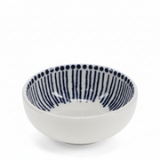 A white ceramic bowl with a navy blue hand-painted pattern of vertical stripes and dots on the inside, shown on a plain white background.