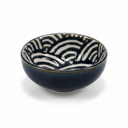 A small ceramic bowl with a glossy dark navy blue exterior and a white interior decorated with a black zebra-like wavy pattern, set against a plain white background.