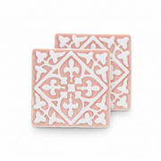 Pink ceramic tile coasters with white embossed pattern, set of two.