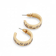 Gold hoop earrings with enamel florals laid diagonally on pale grey background