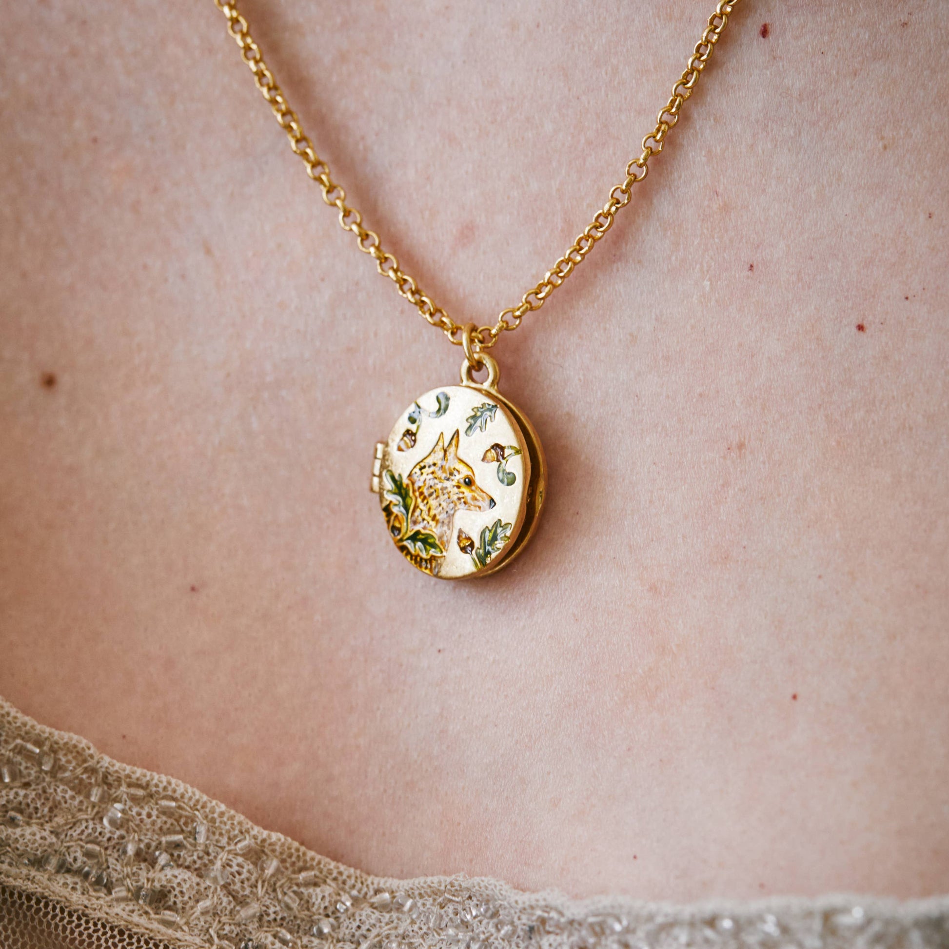 Model wearing Fox and Acorn gold locket necklace - neckline close-up