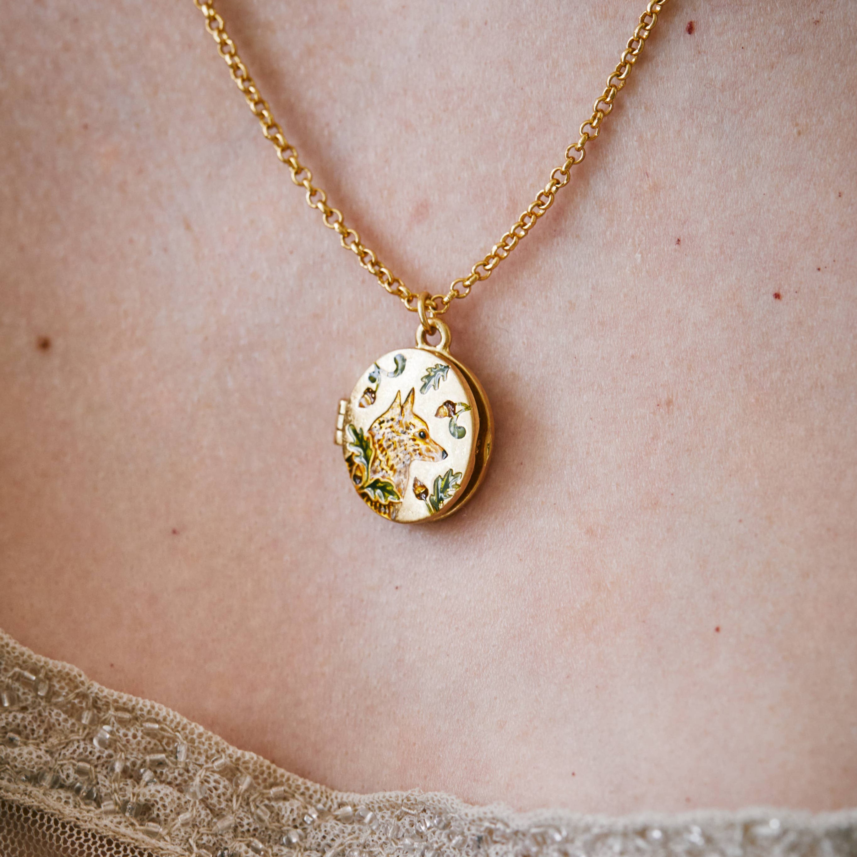 Model wearing Fox and Acorn gold locket necklace - neckline close-up