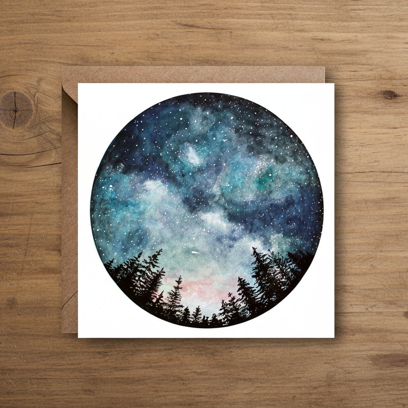 Card with a circular design of a starry night sky and trees, on a white background with a brown envelope.