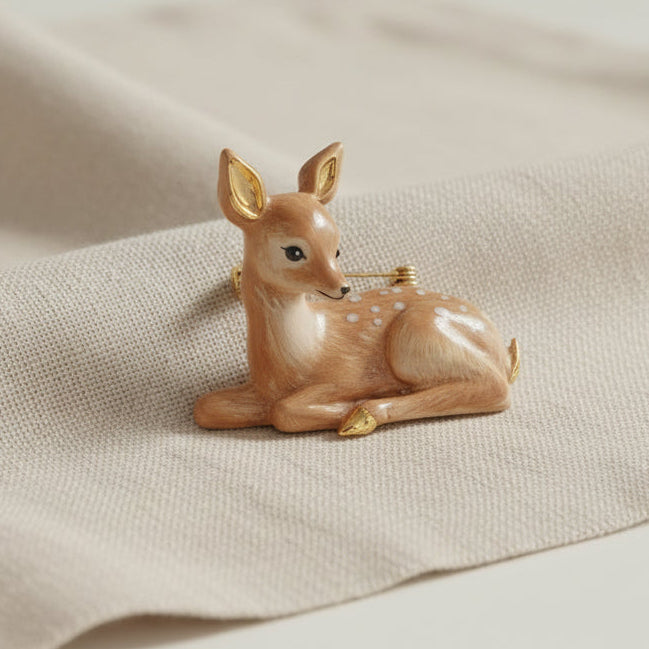 Resting Fawn Enamel Brooch on textured linen fabric surface