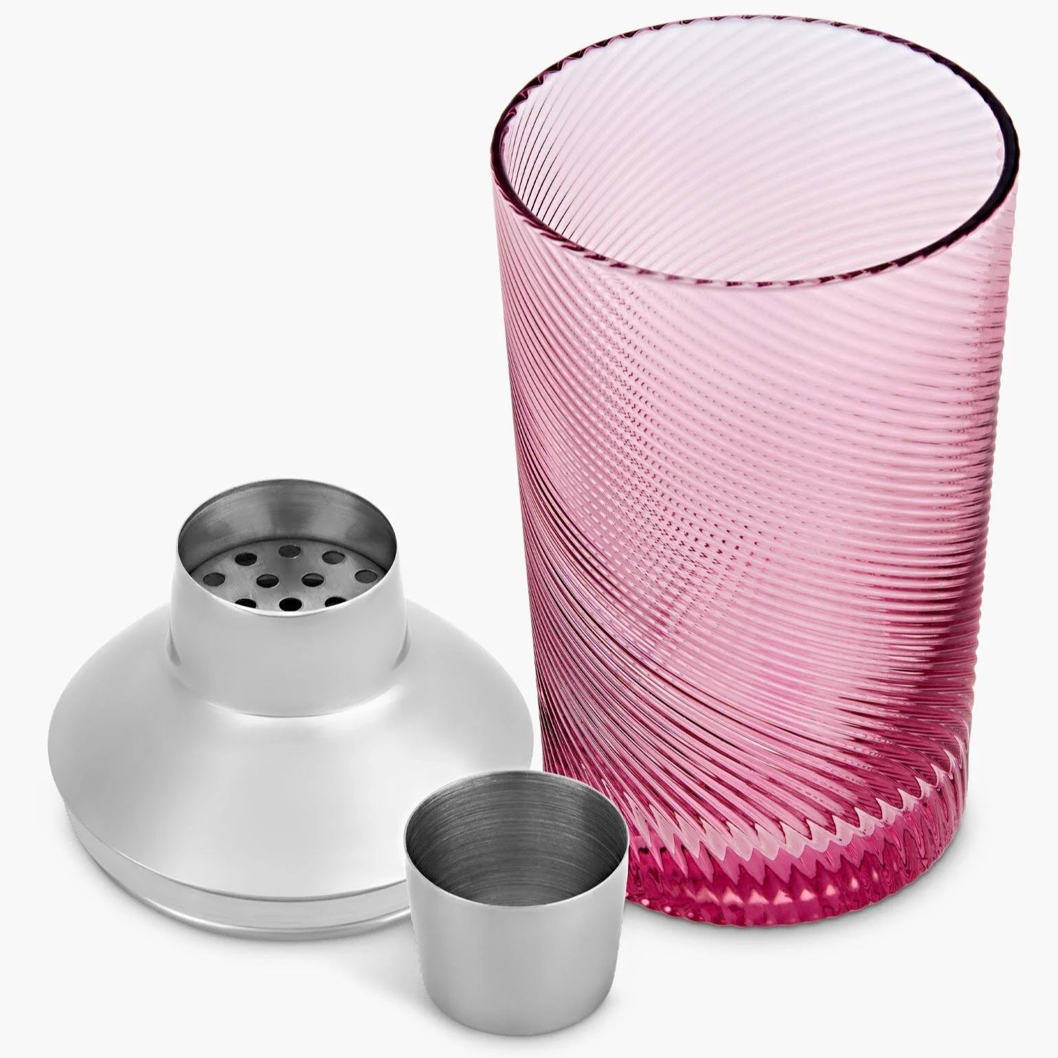 Disassembled pink glass cocktail shaker showing stainless steel lid, strainer, and cap beside the twisted textured glass base.