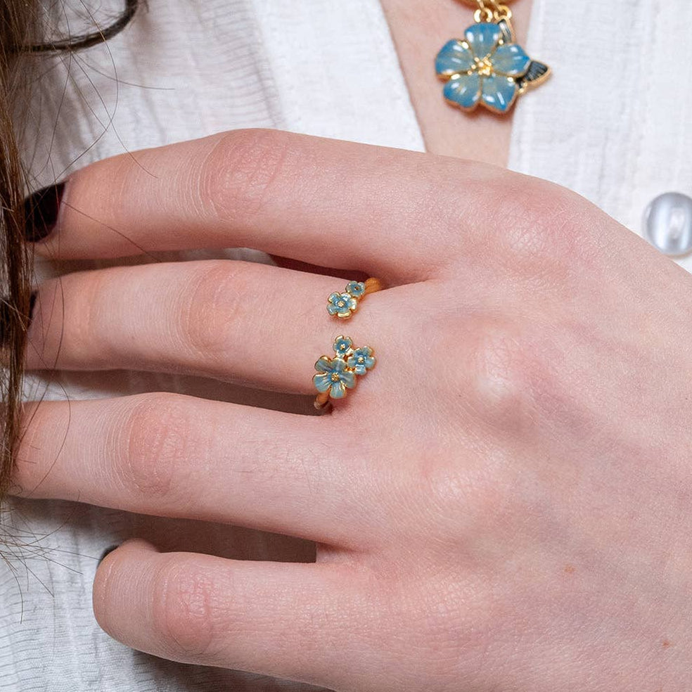 Forget-Me-Not ring worn on hand next to matching flower necklace