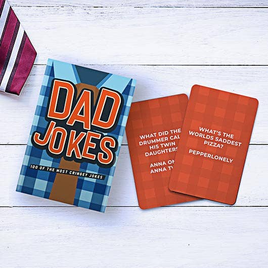 Dad Jokes box and cards displayed on wooden surface with tie
