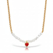 Close-up of the red enamel heart charm and pearls on the gold chain