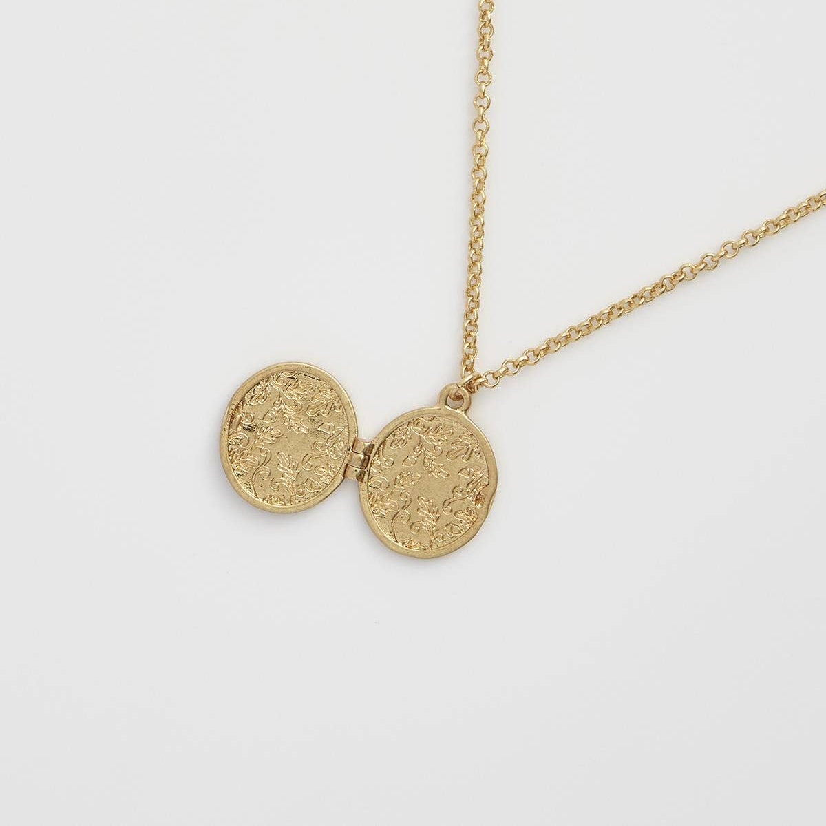 Fox and Acorn locket open from behind showing engraved interior discs