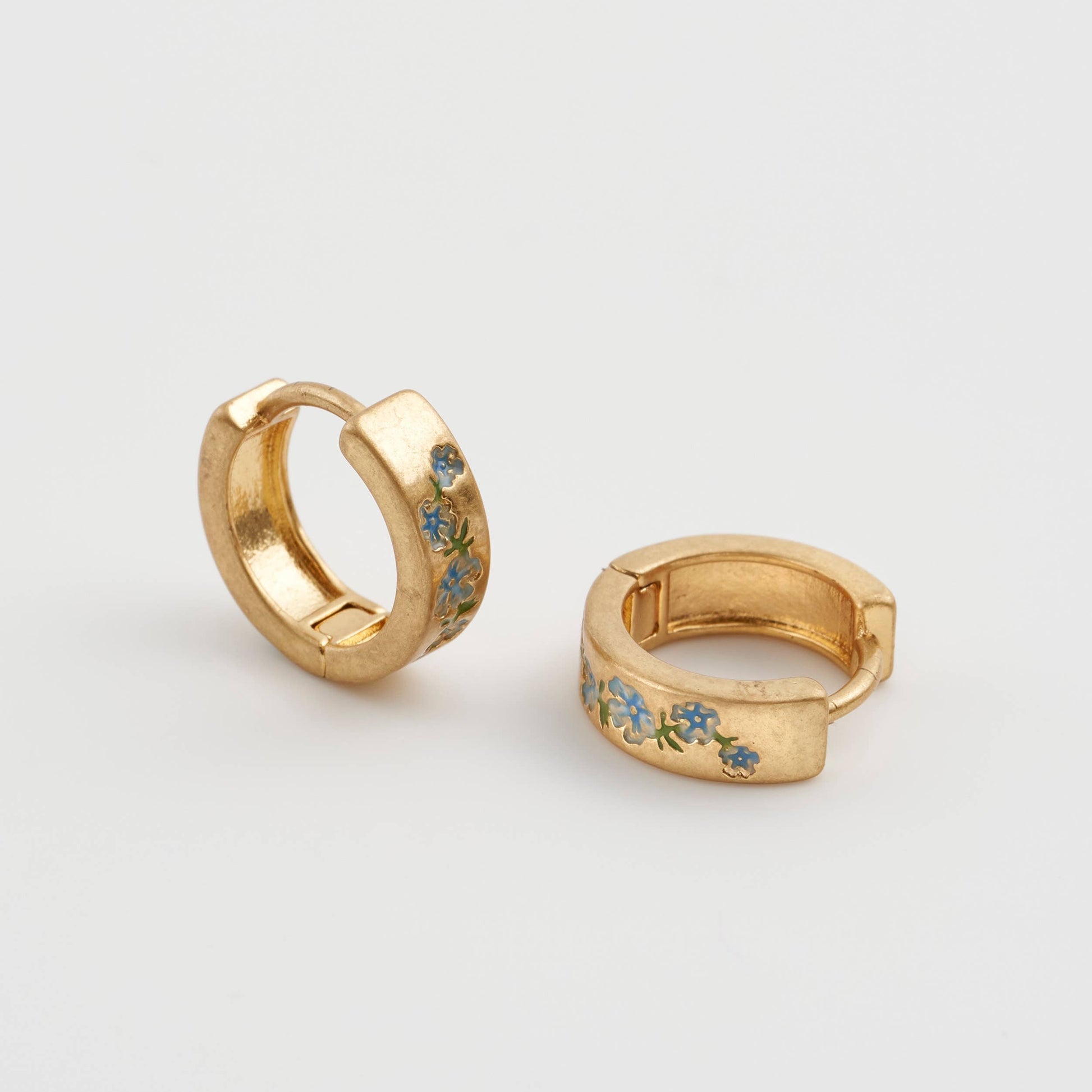Forget-me-not hoop earrings pair, close-up of blue enamel floral detail