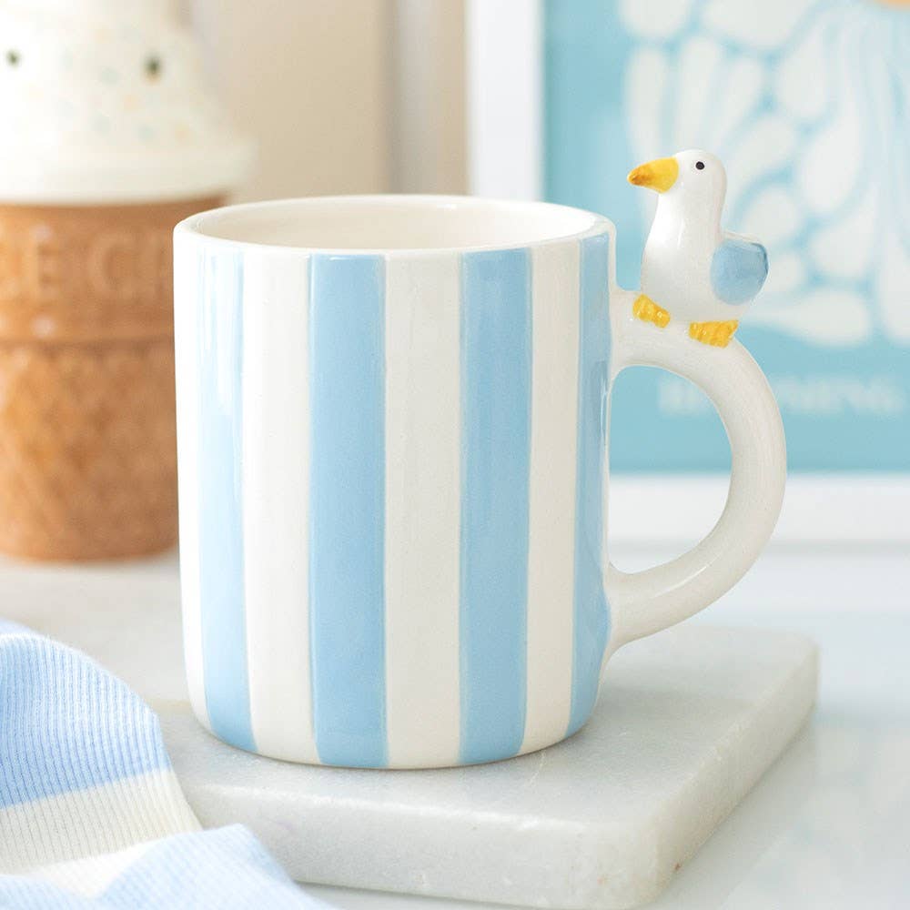 Blue striped mug with seagull handle styled on marble worktop