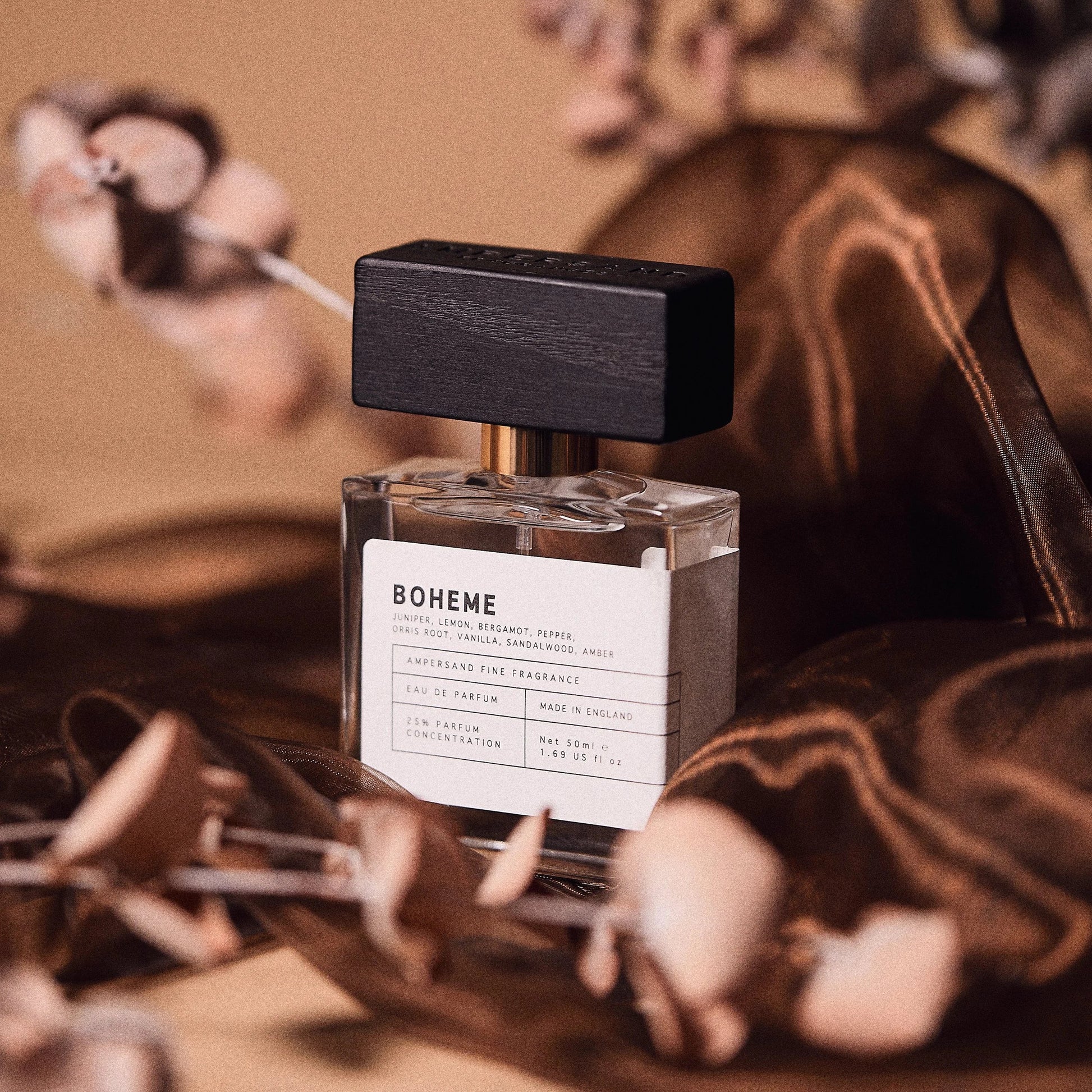 Boheme fragrance bottle with dried flowers on warm surface