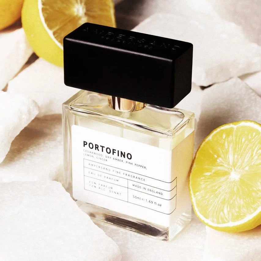 Portofino fragrance bottle styled with fresh lemons on fabric