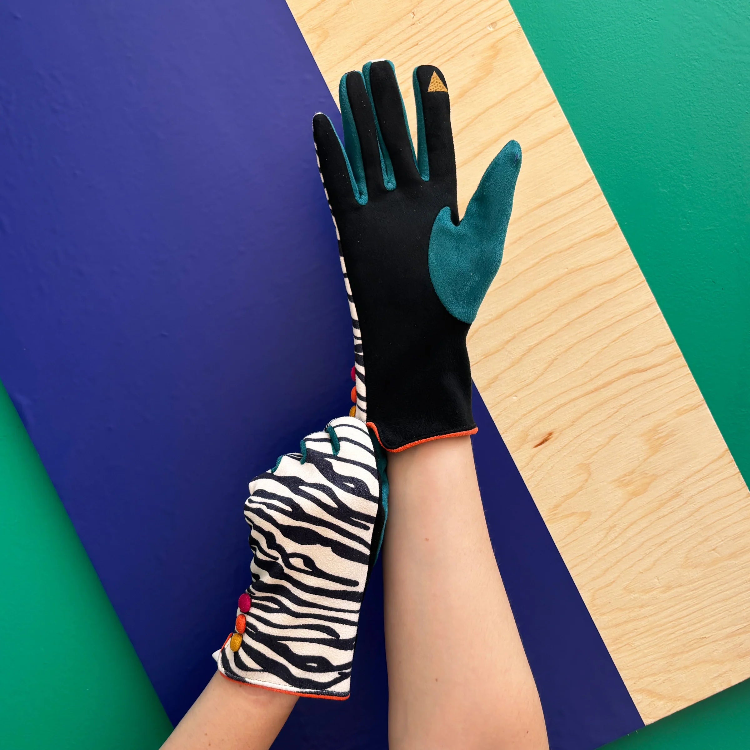 Zebra pattern gloves showing touchscreen friendly fingertip in teal and black.