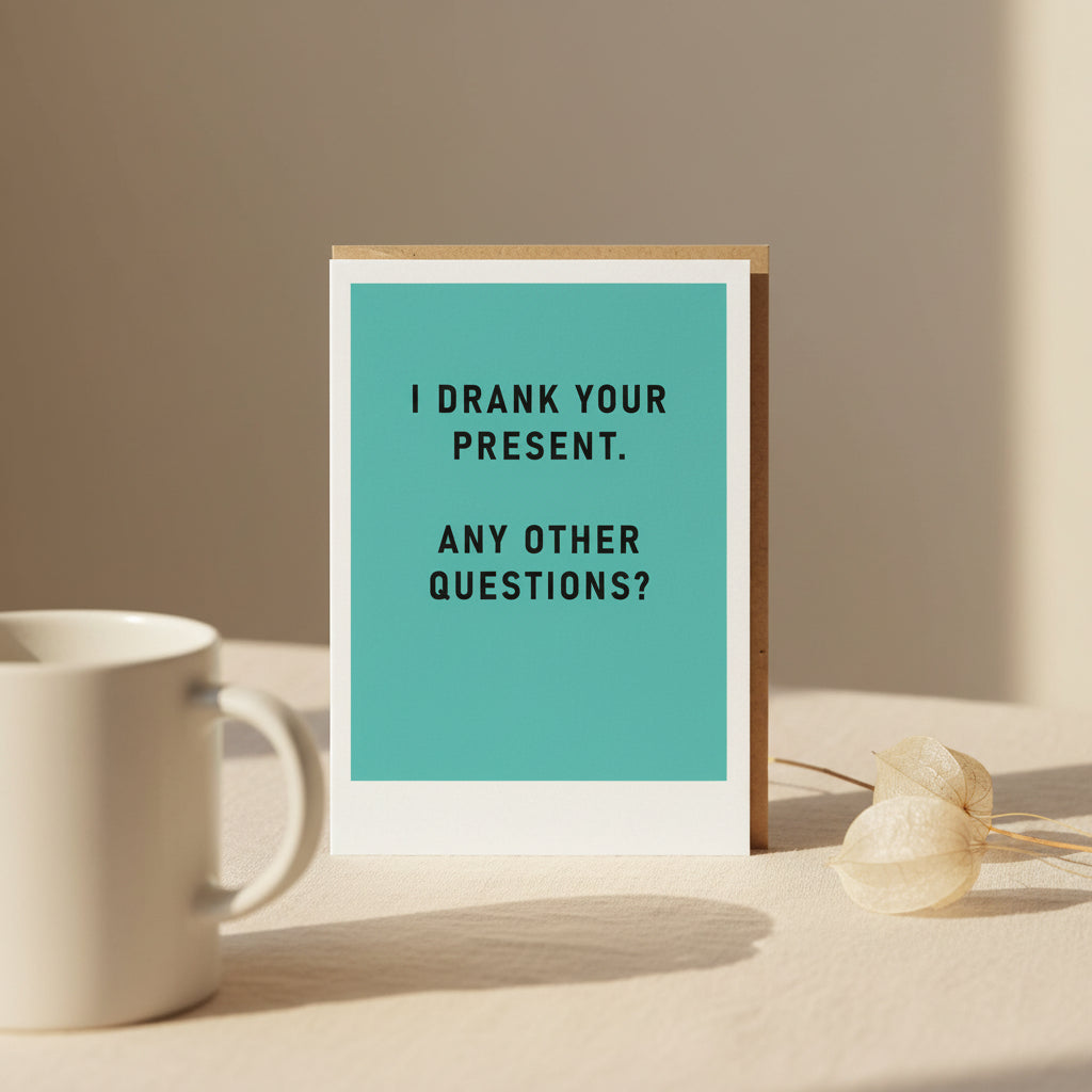 Framed humorous text card with 'I drank your present. Any other questions?' on a teal background.