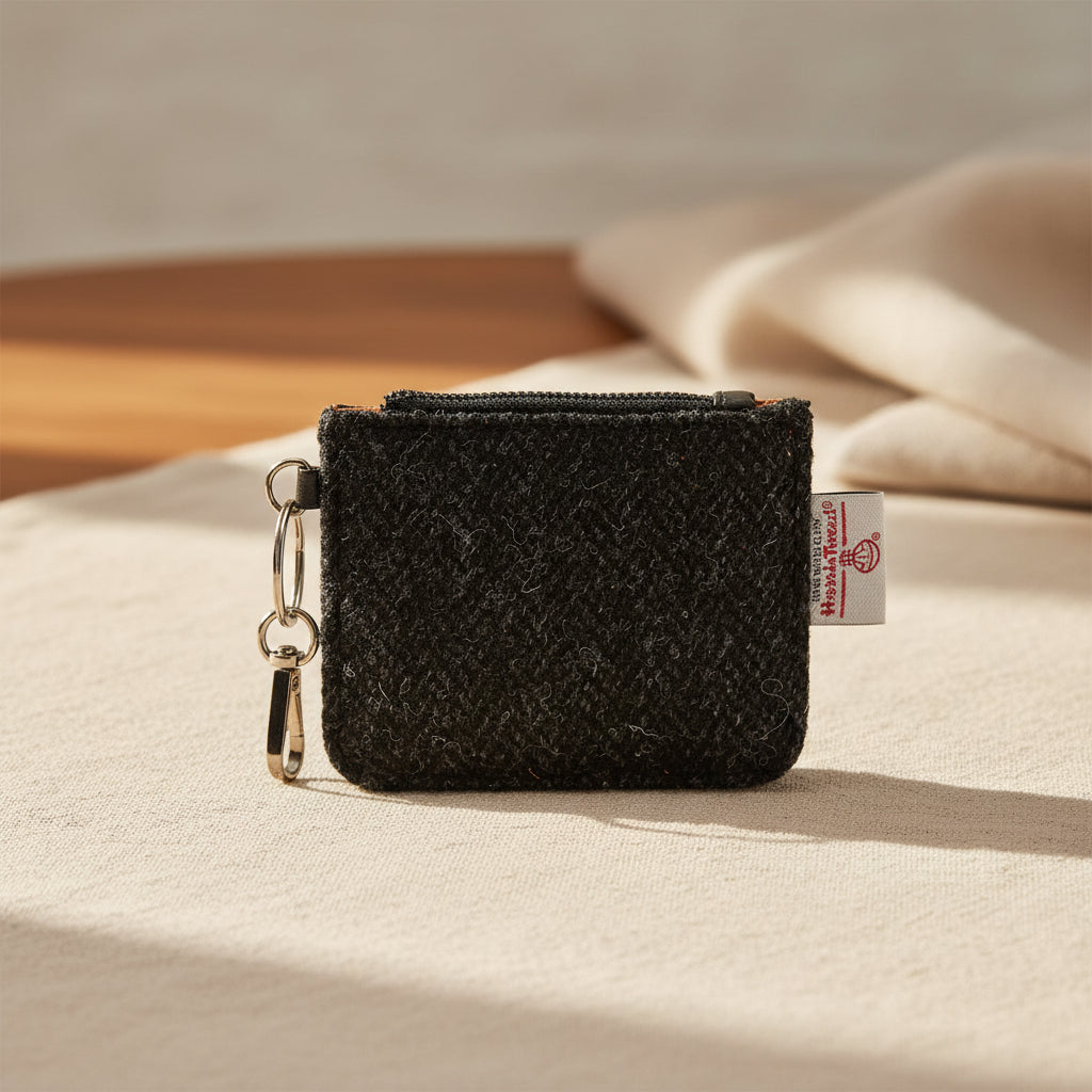 Black textured wallet with a keychain and visible brand tag on a white background