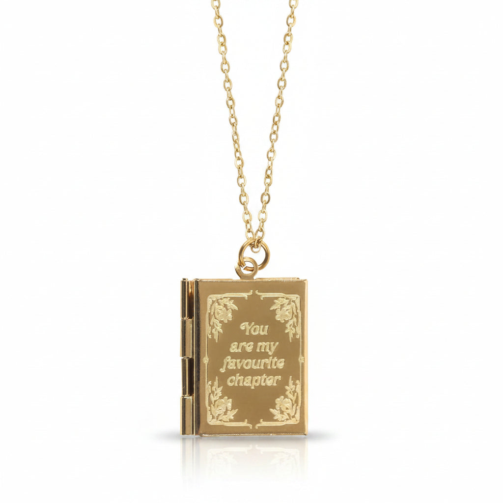 Close-up of the gold-toned locket pendant with engraved floral border and sentimental phrase.
