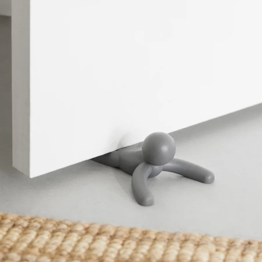 Umbra Buddy doorstop in charcoal holding open a wooden door