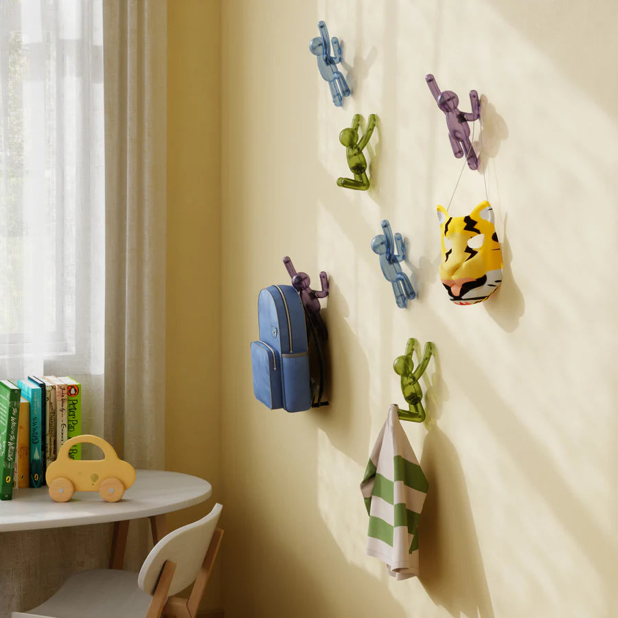 Umbra Buddy pushpin hooks in gem tones mounted on white wall with items