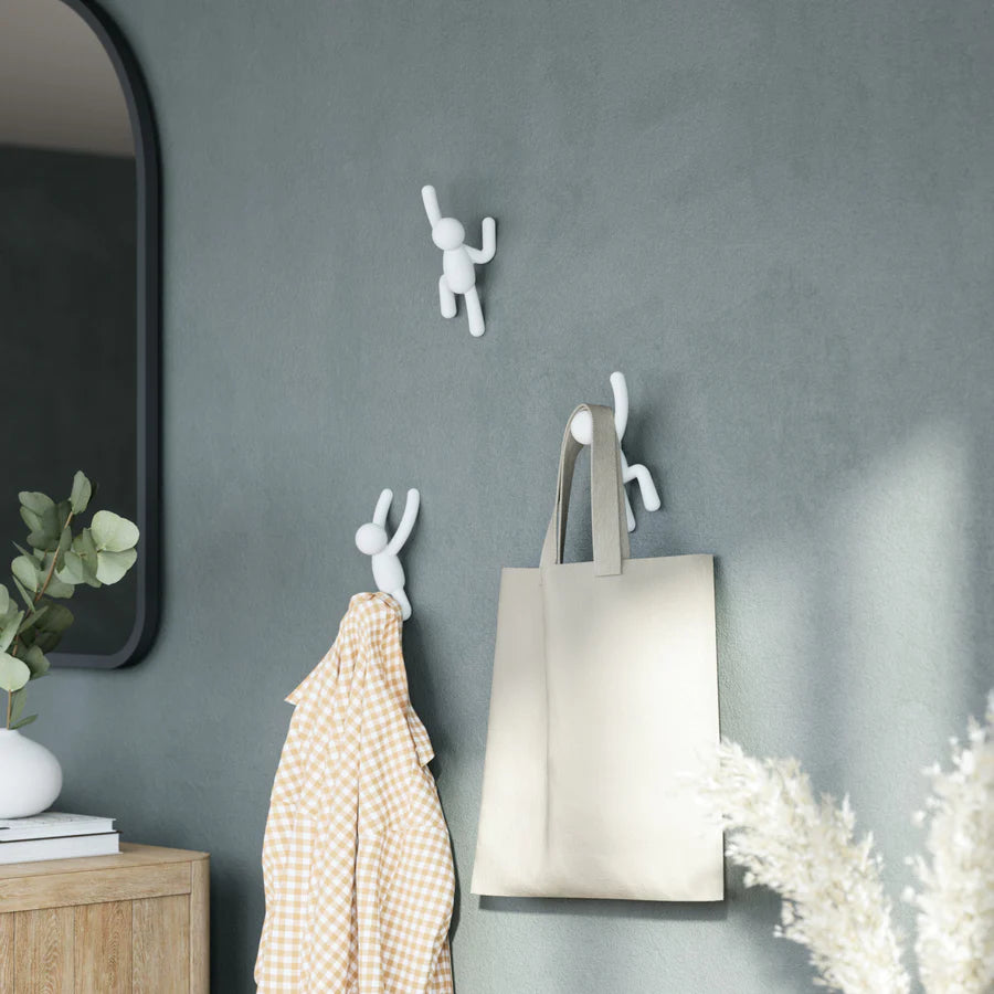 Umbra Buddy white hook set on wall with coats and bags hanging