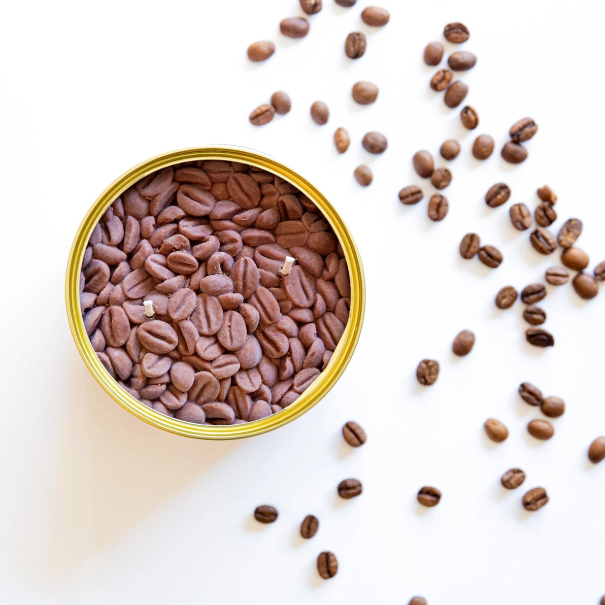 Flat lay of Coffee CandleCan surrounded by scattered roasted coffee beans on a white background, showcasing its realistic coffee wax finish.