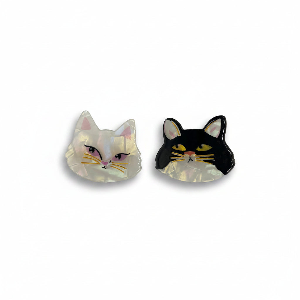 A pair of cat-shaped hair clips isolated on a white background, showing off their acrylic material and detailed design.