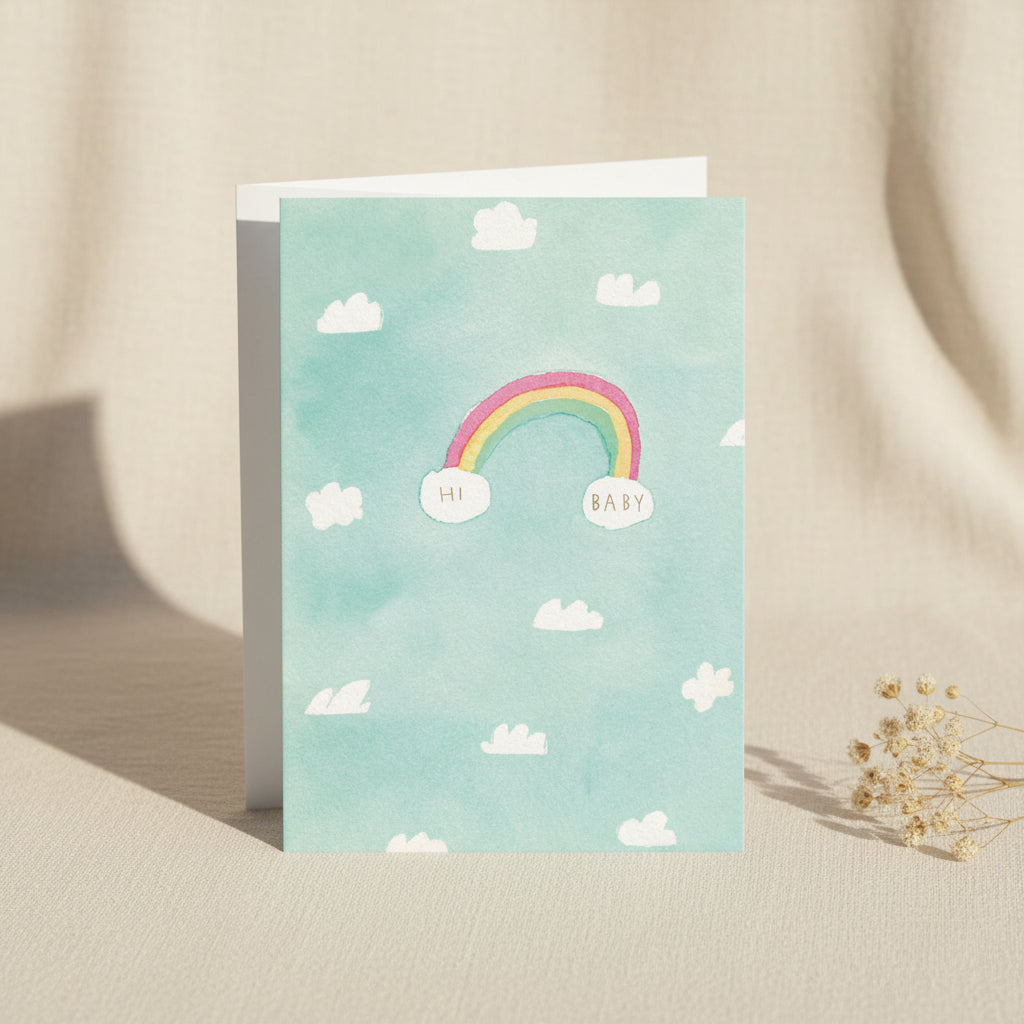 Card with a rainbow and clouds on a light blue background