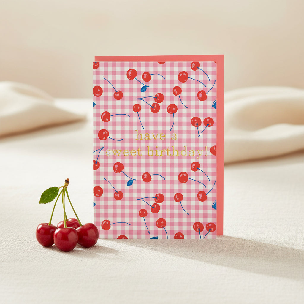 Greeting card with cherry pattern and 'have a sweet birthday!' text on a pink checkered background