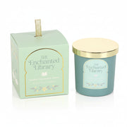 The Enchanted Library scented candle with gold lid beside illustrated green gift box.