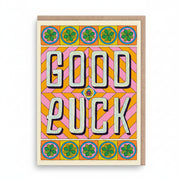Cream good luck card with bold retro lettering and green four-leaf clovers