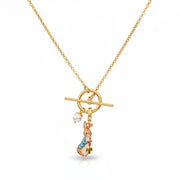 Close-up of gold Peter Rabbit enamel charm necklace with faux pearl detail.