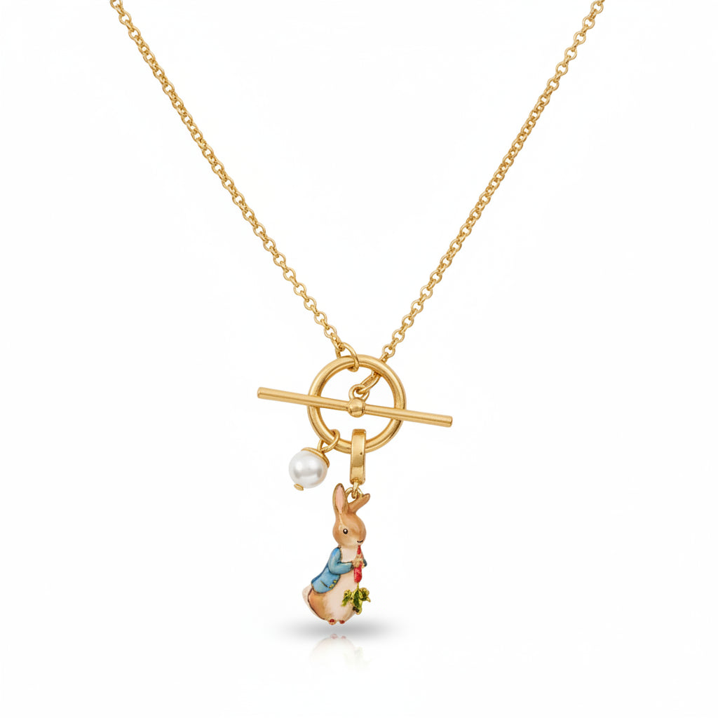 Close-up of gold Peter Rabbit enamel charm necklace with faux pearl detail.
