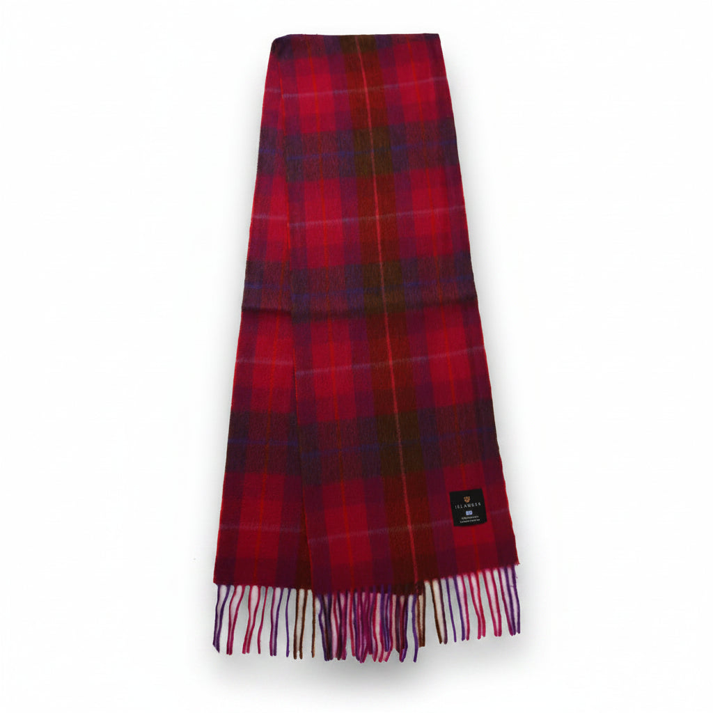 Fuchsia red tartan lambswool scarf with fringed edges laid flat.