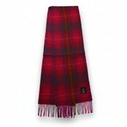 Fuchsia red tartan lambswool scarf with fringed edges laid flat.