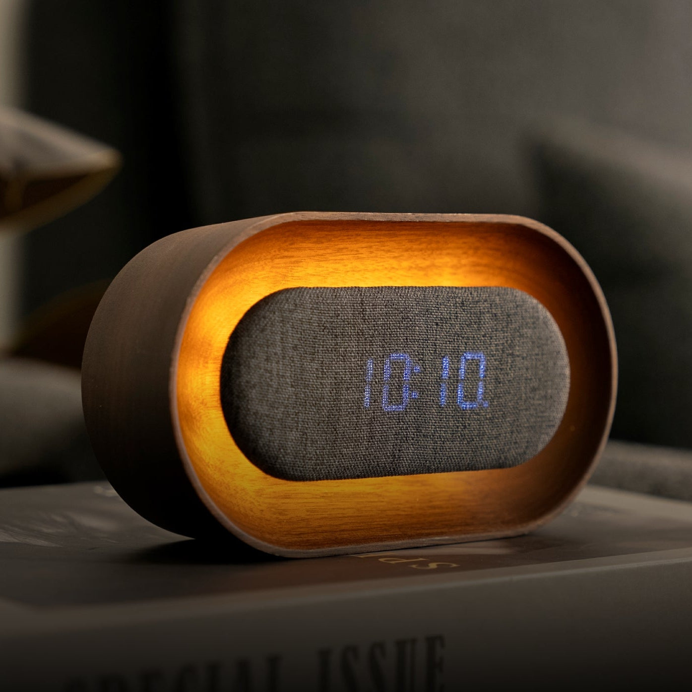 Lumos oval walnut clock lit at night in cosy living room