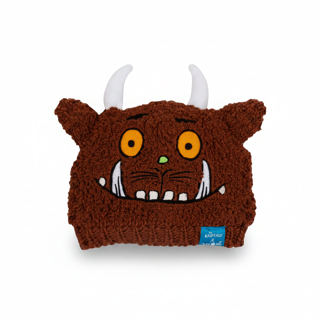 Gruffalo Winter Hat flat lay showing embroidered Gruffalo face, horns, and ears on brown knit background.