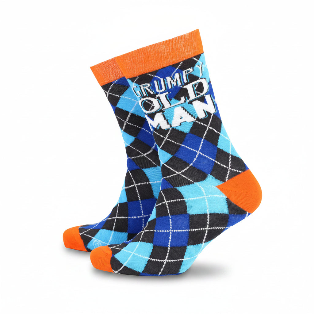 Front-facing image of men’s bamboo socks featuring a bold blue and black argyle pattern, bright orange heel and toe accents, and the phrase “Grumpy Old Man” stitched across the calf—perfect for novelty gift shoppers.