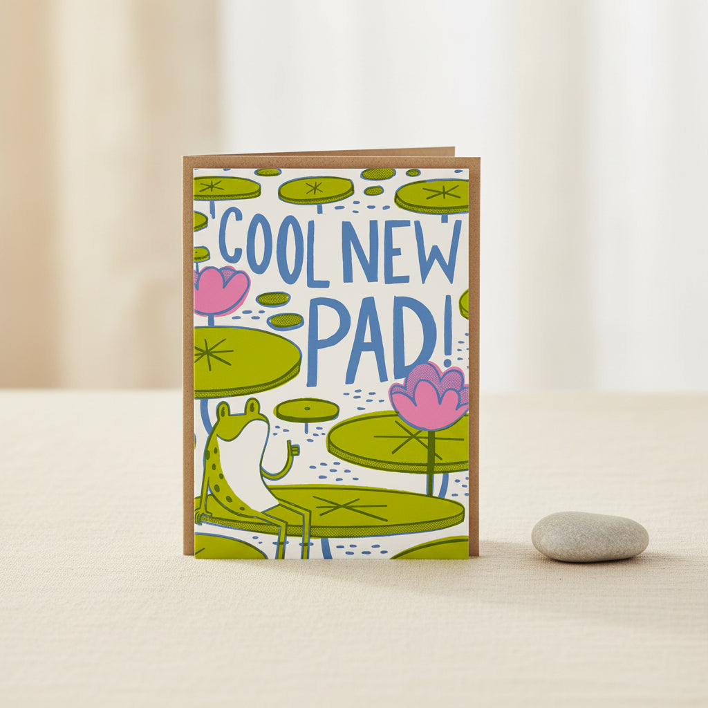 Greeting card with frog, lily pads, and 'Cool New Pad!' text on a white background