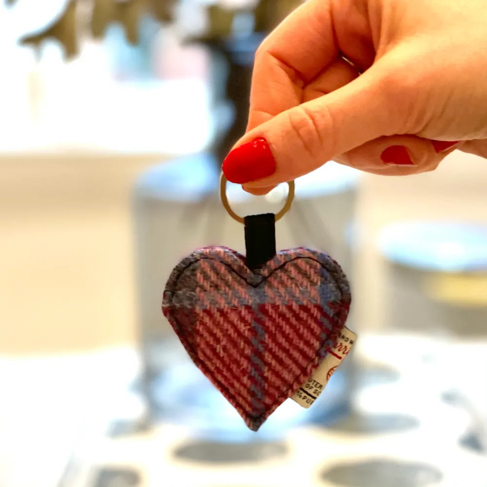 Harris Tweed heart keyring dangling from hand in gift shop setting
