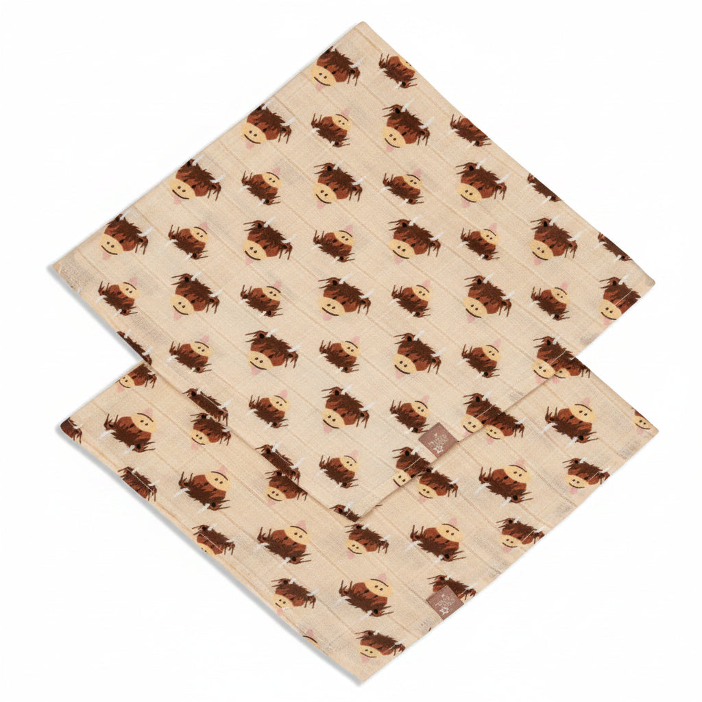 Two highland cow muslin squares flat on split background