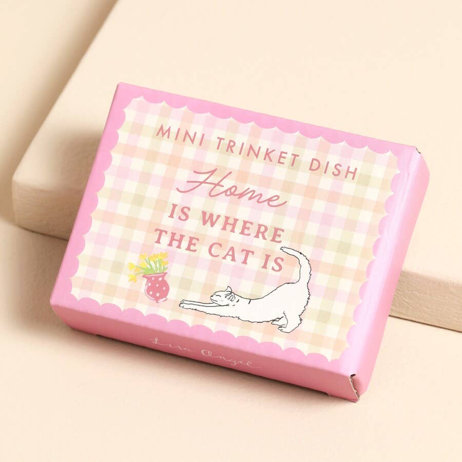 Pink ceramic trinket dish with stretching cat and vase illustration, holding gold jewellery.