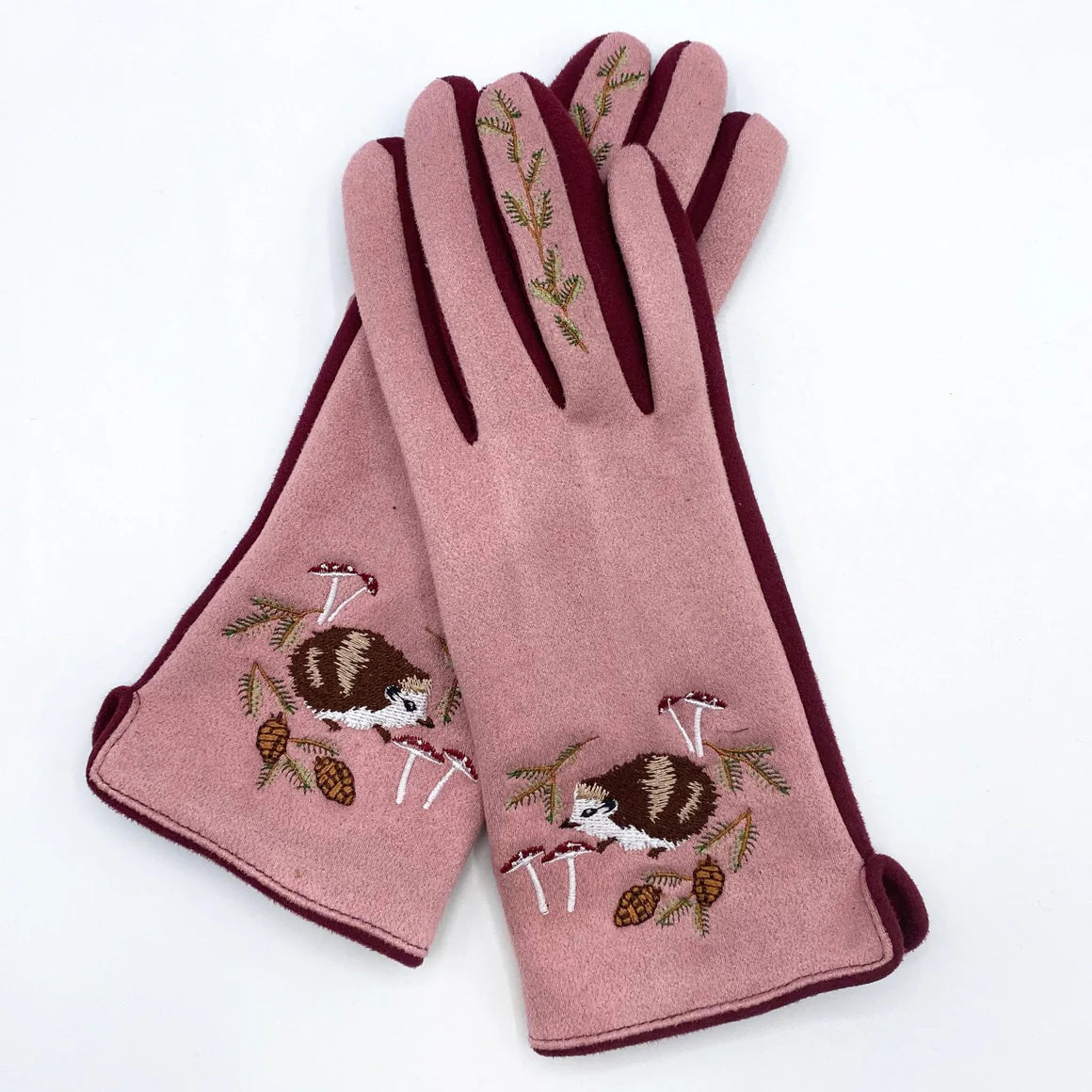 Detailed close-up of hedgehog and greenery embroidery on navy blue fashion gloves.