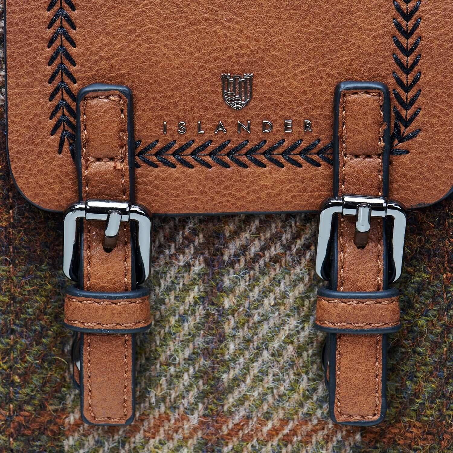 Close-up of the chestnut tartan Harris Tweed phone tote bag, highlighting its sturdy metal buckles and intricate fabric detail.