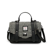 Black and white dogtooth Harris Tweed satchel with black handle on white background