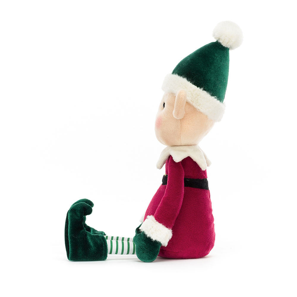 Side view of Jellycat Eldo Elf sitting upright with striped elf tights and pointed ears.