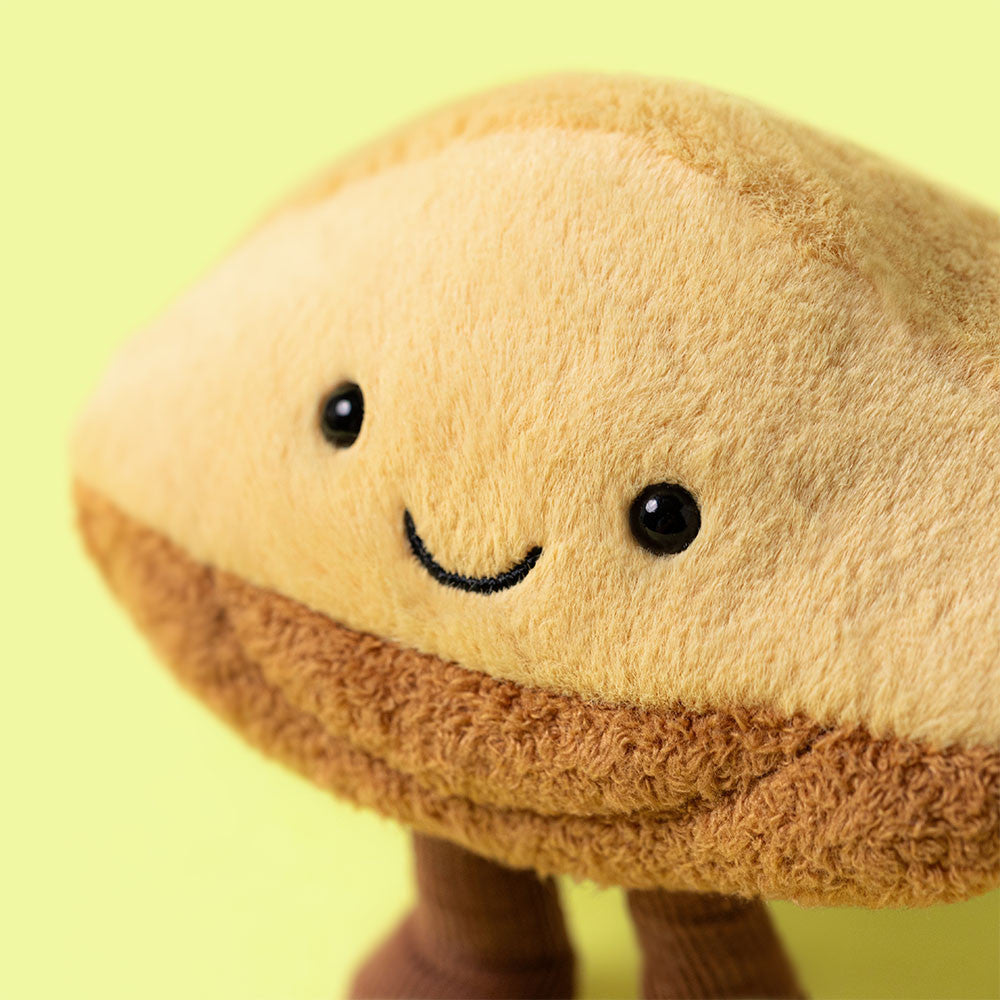 Close-up of Jellycat Margaux Madeleine face on yellow background