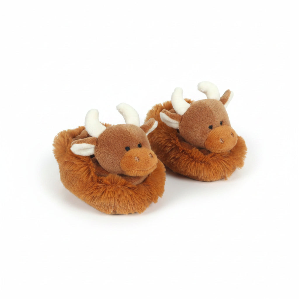 Pair of brown plush slippers shaped like deer on a light wooden surface
