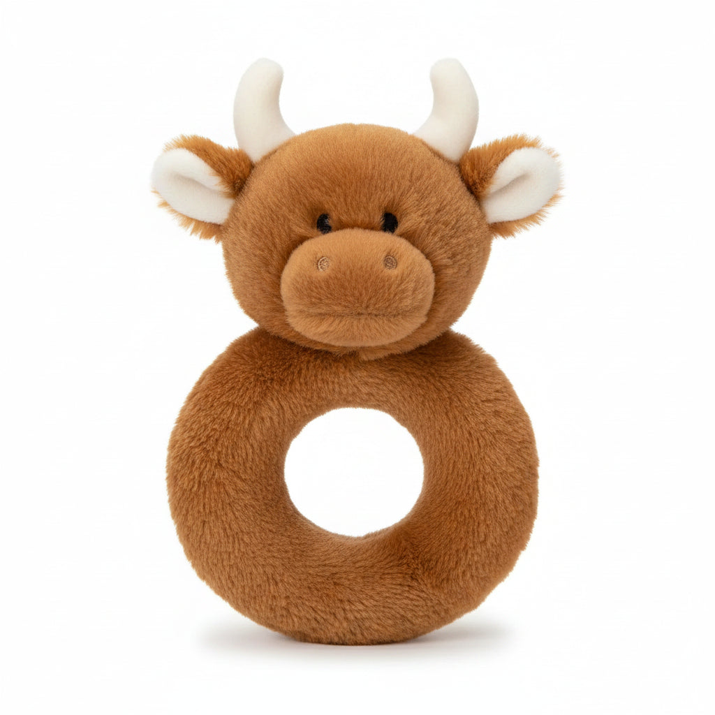 Plush toy ring with a cow design on a light wooden surface