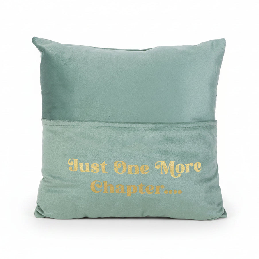 Cushion with gold lettering and pocket holding a book.